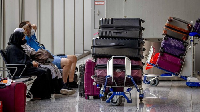 Passengers queue at check in counters at the international airport in Frankfurt, Germany, Wednesday, July 27, 2022. Lufthansa went for a 24-hours-strike on Wednesday, most of the Lufthansa flights had to be cancelled. (AP Photo/Michael Probst)