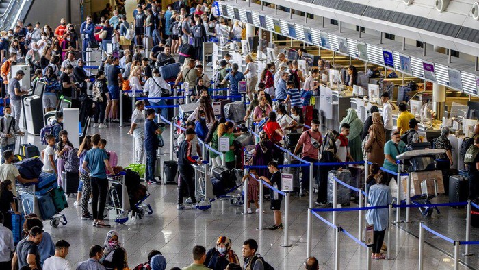 Passengers queue at check in counters at the international airport in Frankfurt, Germany, Wednesday, July 27, 2022. Lufthansa went for a 24-hours-strike on Wednesday, most of the Lufthansa flights had to be cancelled. (AP Photo/Michael Probst)