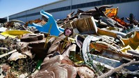 Dinosaurus raksasa dan model mainan robot ditinggalkan di antara wahana taman hiburan yang sudah tidak berfungsi.