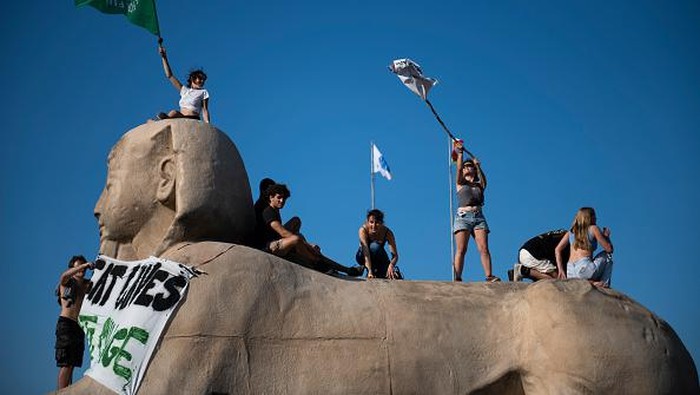 Aktivis Lingkungan Italia Gelar Aksi di Atas Patung Sphinx TURIN, ITALY - JULY 27: Activists of Fridays For Future above the advertising sphinx of the Egyptian Museum of Turin in the roundabout of access to the northern ring road of Turin during a flashmod on July 27, 2022 in Turin, Italy. The Climate Social Camp brings together climate activists, movements and collectives to help unite in common action against the threat of Climate Change. (Photo by Stefano Guidi/Getty Images)
