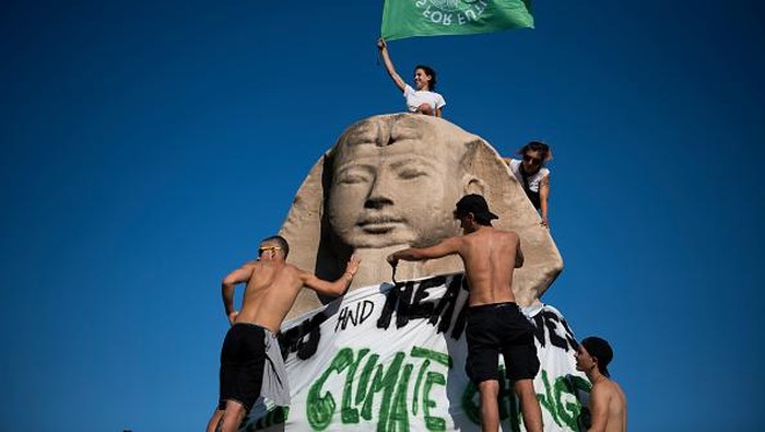 TURIN, ITALY - JULY 27: Activists of Fridays For Future above the advertising sphinx of the Egyptian Museum of Turin in the roundabout of access to the northern ring road of Turin during a flashmod on July 27, 2022 in Turin, Italy. The Climate Social Camp brings together climate activists, movements and collectives to help unite in common action against the threat of Climate Change. (Photo by Stefano Guidi/Getty Images)