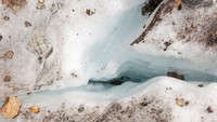 Es meleleh mengalir ke celah es di Gletser Pers dekat resor Alpine Pontresina, Swiss. Gletser di Himalaya juga menjadi salah satu yang terdampak dari pemanasan global. 