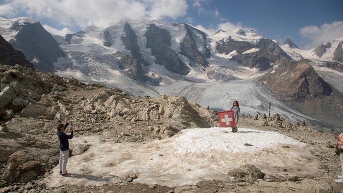Bumi Makin Panas, Gletser Pegunungan Alpen Terancam Hilang Glaciologist Andreas Linsbauer and assistant Andrea Millhaeusler drill a hole at a measuring point on the Pers Glacier near the Alpine resort of Pontresina, Switzerland July 21, 2022. REUTERS/Arnd Wiegmann