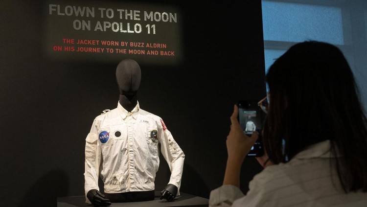 NEW YORK, NEW YORK - JULY 21: A woman takes a photo of Buzz Aldrins Inflight Coverall Jacket during the Apollo 11 mission is on display during a press preview at Sothebys on July 21, 2022 in New York City. Buzz Aldrins inflight jacket along with other pieces from his collection will be auctioned on July 26, 2022. (Photo by Alexi Rosenfeld/Getty Images)