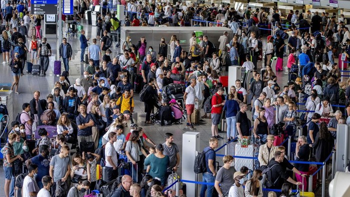Passengers queue at check in counters at the international airport in Frankfurt, Germany, Wednesday, July 27, 2022. Lufthansa went for a 24-hours-strike on Wednesday, most of the Lufthansa flights had to be cancelled. (AP Photo/Michael Probst)