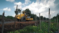 Pekerja mengoperasikan alat berat saat proses pengerasan tanah di lokasi pembangunan Tol Yogyakarta-Bawen Seksi 1 di Seyegan, Sleman, D.I Yogyakarta, Rabu (27/7/2022).   