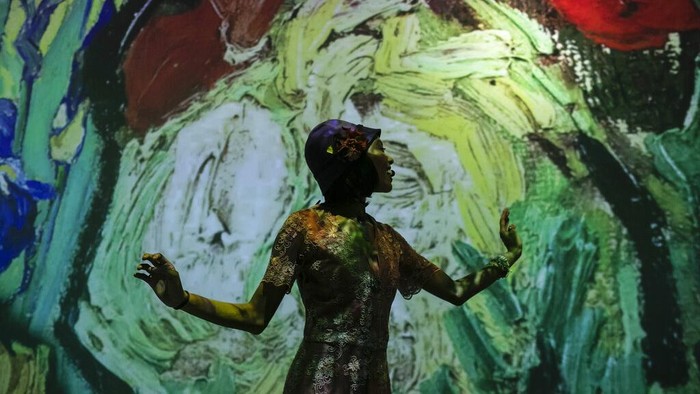 Guests and journalists stand in the Van Gogh Live 8K multimedia exhibition featuring projections of paintings by Dutch artist Vincent Willem van Gogh at the exhibit's opening for the media and guests in Rio de Janeiro, Brazil, Wednesday, July 27, 2022. (AP Photo/Bruna Prado)