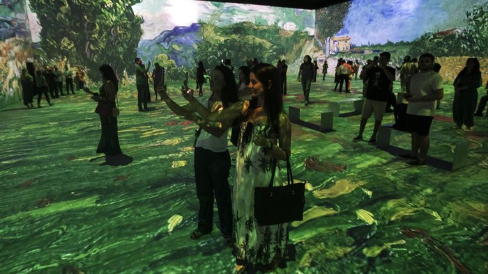 Menikmati Pameran Interaktif Mahakarya Van Gogh di Brasil Guests and journalists stand in the Van Gogh Live 8K multimedia exhibition featuring projections of paintings by Dutch artist Vincent Willem van Gogh at the exhibit's opening for the media and guests in Rio de Janeiro, Brazil, Wednesday, July 27, 2022. (AP Photo/Bruna Prado)