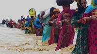 Warga berbaris melawan arus banjir yang cukup kencang. Tentara turut membantu pemerintah lokal di Baluchistan untuk mengevakuasi orang-orang dari daerah yang terdampak banjir.  