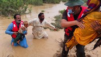 Petugas penyelamat membantu penduduk desa untuk evakuasi di Lasbella, sebuah distrik di provinsi Baluchistan barat daya Pakistan, Selasa (26/7/2022) waktu setempat. Lokasinya jauh dari ibu kota, sekitar 1.200 km dari Islamabad.