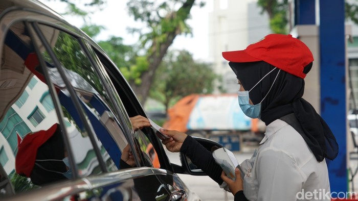 Petugas SPBU mengisi bahan bakar minyak.