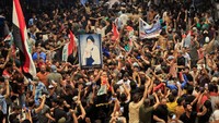Foto pemimpin tertinggi mereka dibawa oleh para demonstran. Aliansi politik Sadr memenangkan kursi terbanyak dalam pemilihan umum Oktober lalu, tetapi tidak berkuasa karena kebuntuan politik.