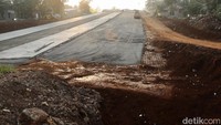 Sebagian jalan masih tanah merah menunggu proses kontruksi selesai. Pembangunan proyek tol ini sempat terkendala pembebasan lahan.