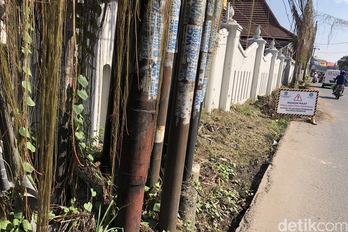 Proyek penggalian parit terlihat belum selesai di Jl Pondok Betung Raya, Pondok Aren, Tangerang Selatan, Kamis (28/7/2022). Penggalian parit tersebut terbentur banyaknya tiang utilitas yang belum dipindahkan.