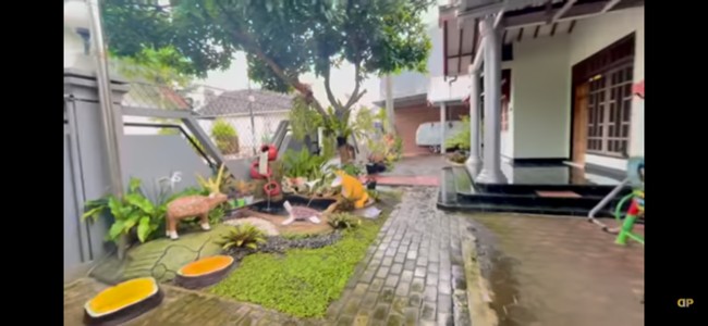 Taman di depan rumah menghadirkan kesan asri. Keluarga Dewi Perssik juga memfungsikan area depan sebagai garasi. (Foto: YouTube/Dewi Perssik)