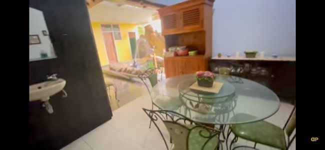 Ruang makan keluarga Dewi Perssik memiliki pemandangan unik: sebuah kolam ikan yang dihiasi patung duyung. Di bagian lainnya, terdapat pula sebuah kolam renang kecil, tempat Dewi Perssik sering berenang semasa kecil. (Foto: YouTube/Dewi Perssik)