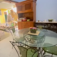 Ruang makan keluarga Dewi Perssik memiliki pemandangan unik: sebuah kolam ikan yang dihiasi patung duyung. Di bagian lainnya, terdapat pula sebuah kolam renang kecil, tempat Dewi Perssik sering berenang semasa kecil. (Foto: YouTube/Dewi Perssik)