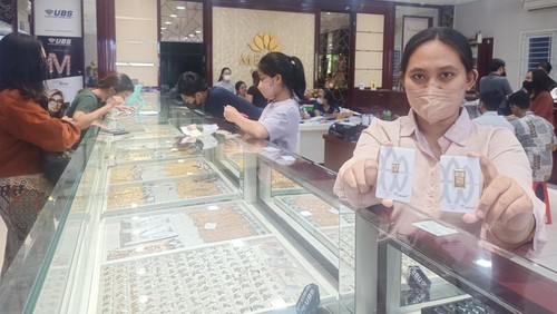 Salah satu karyawan Melati Gold Shop, Jalan Diponegoro No 116, Denpasar, Bali, menunjukkan emas batangan Antam pada Kamis (28/7/2022).