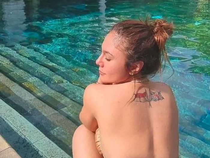 wulan guritno pose di pinggir kolam renang.