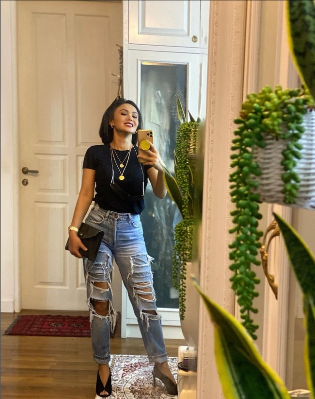 Busana simpel bisa terlihat lebih glamor dan estetik dengan tambahan aksesori seperti kalung berlapis, jam tangan dan high heels. Seperti gaya yang ditunjukkan Yuni Shara ini dengan jeans sobek-sobeknya. Foto: Instagram/@yunishara36
