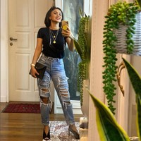 Busana simpel bisa terlihat lebih glamor dan estetik dengan tambahan aksesori seperti kalung berlapis, jam tangan dan high heels. Seperti gaya yang ditunjukkan Yuni Shara ini dengan jeans sobek-sobeknya. Foto: Instagram/@yunishara36