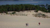 Orang-orang berjalan di Dune du Pilat, bukit pasir tertinggi di Eropa.