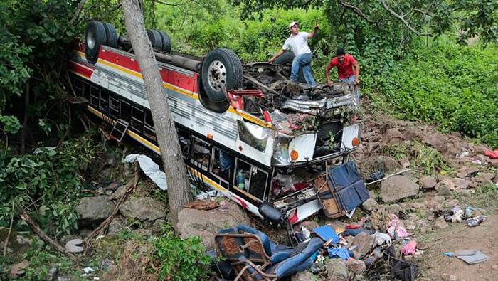 Workers try to remove a crashed bus at the Pan-American highway in Condega, Nicaragua, on July 28, 2022. - A traffic accident that occurred Wednesday night on a highway in northern Nicaragua left 16 people dead, including 13 Venezuelans, presumably migrants, in addition to 47 injured, the National Police reported Thursday. (Photo by Oswaldo Rivas / AFP) (Photo by OSWALDO RIVAS/AFP via Getty Images)
