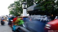 Warga melintas di samping tugu yang berada di tengah jalan. Tugu tersebut akan direlokasi 10 meter ke arah selatan karena mengganggu lalin.