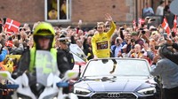 Jonas Vingegaard diarak menggunakan mobil terbuka menuju balai kota Kopenhagen. Ia terus tersenyum dan melambaikan tangan ke penonton. (Sergei Gapon/Anadolu Agency/Getty Images)