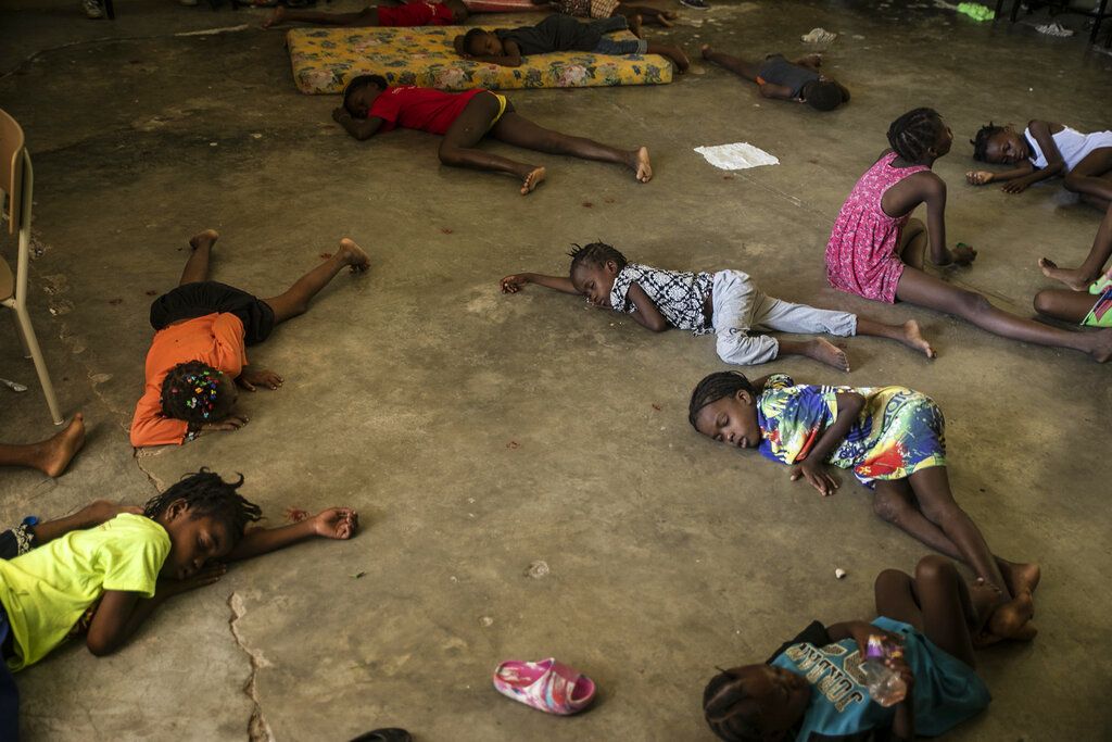 Children sleep on the floor of a school turned into a shelter after they were forced to leave their homes in Cite Soleil due to clashes between armed gangs, in Port-au-Prince, Haiti, Saturday, July 23, 2022. (AP Photo/Odelyn Joseph)