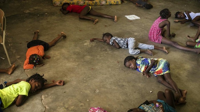 Children sleep on the floor of a school turned into a shelter after they were forced to leave their homes in Cite Soleil due to clashes between armed gangs, in Port-au-Prince, Haiti, Saturday, July 23, 2022. (AP Photo/Odelyn Joseph)
