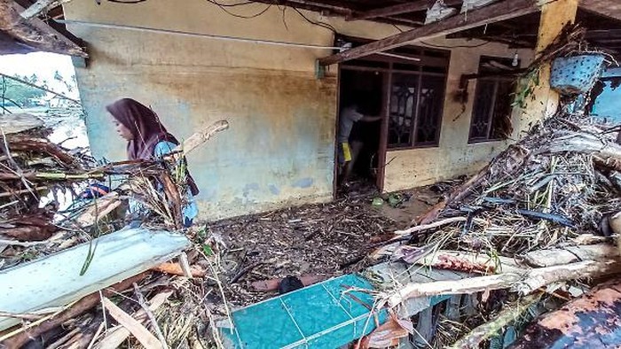 Mobil Terbalik-Rumah Hancur Gegara Banjir Bandang di Torue, Sulteng Residents examine their home and surroundings at Torue, in Central Sulawesi on July 29, 2022, after flash floods devastated houses and vehicles, and took lives. (Photo by RIDWAN / AFP) (Photo by RIDWAN/AFP via Getty Images)