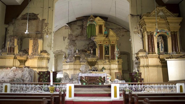 Ratusan Gempa Susulan Goyang Filipina, Gereja hingga Rumah Roboh A man looks at the damaged Saint Catherine of Alexandria Church a day after a strong quake struck Tayum, Abra province, northern Philippines on Thursday, July 28, 2022. A 7-magnitude quake set off landslides and damaged buildings in the northern Philippines on Wednesday, killing some people and injuring dozens. (AP Photo/ Czeasar Dancel)
