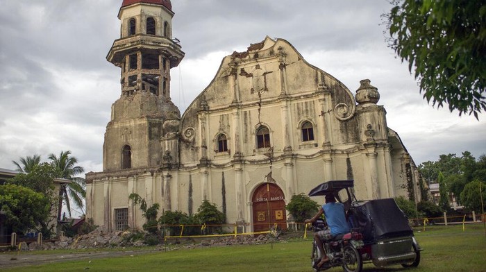 A man looks at the damaged Saint Catherine of Alexandria Church a day after a strong quake struck Tayum, Abra province, northern Philippines on Thursday, July 28, 2022. A 7-magnitude quake set off landslides and damaged buildings in the northern Philippines on Wednesday, killing some people and injuring dozens. (AP Photo/ Czeasar Dancel)