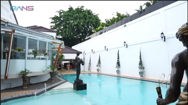 Di halaman belakang, terdapat kolam renang. Tadinya halaman di belakang sangat luas sebelum akhirnya terbagi dua, dampak perpisahan Hotma dengan sang istri, Desiree Tarigan.   (Foto: YouTube/Rans Entertainment)