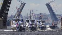 Kapal perang melewati jembatan gantung Sungai Neva menuju Laut Baltik saat latihan parade Angkatan Laut di St.Petersburg, Rusia, Kamis, (28/7/2022). (AP/Dmitri Lovetsky)