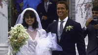 Aktor Arnold Schwarzenegger bersama dengan istri barunya Maria Shriver Schwarzenegger pada hari pernikahannya di depan Gereja St. Francis Xaviers. Steve Liss/Getty Images.