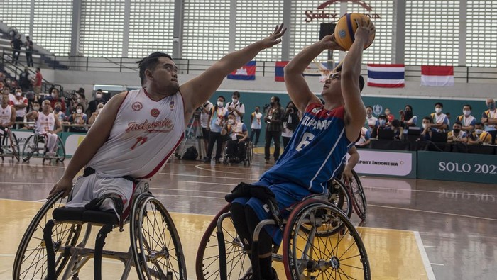 Pebasket Indonesia Kasep Ayatulloh (kiri) mencoba menghalau bola yang dikuasai pebasket Filipina pada pertandingan pertama basket kursi roda ASEAN Para Games 2022 di GOR Sritex Arena, Solo, Jawa Tengah, Sabtu( 30/7/2022). Indonesia kalah dengan skor 10-15. ANTARA FOTO/Muhammad Adimaja/tom.