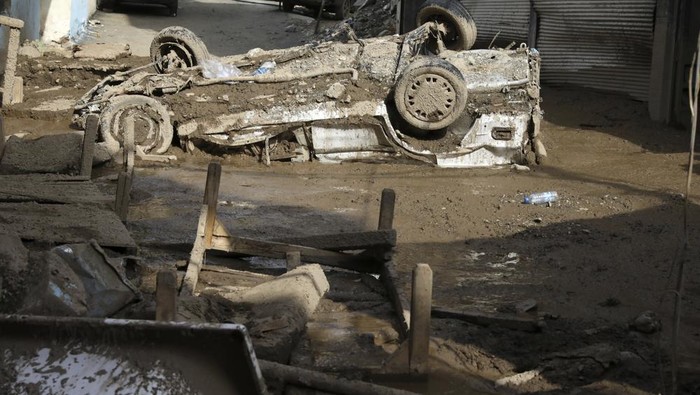 A damaged car is stuck in the mud upside down after flash floods in the northwestern part of Tehran, Iran, Thursday, July 28, 2022. Heavy rains in the early hours of Thursday caused flash floods and then landslides and caused damage to Imamzadeh Davood, a religious shrine in the city. (AP Photo/Vahid Salemi)