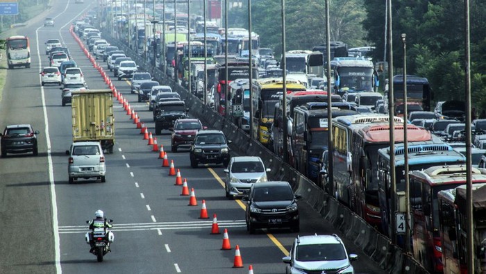 Wisatawan keluar dari kendaraan saat menunggu antrean panjang kendaraan menuju kawasan wisata Puncak, Gadog, Kabupaten Bogor, Jawa Barat, Sabtu  (30/7/2022).  Sat Lantas Polres Bogor memberlakukan sistem buka tutup jalur untuk mengurai kepadatan kendaraan di jalur Puncak Bogor imbas tingginya antusiasme warga untuk berlibur di kawasan tersebut pada libur Tahun Baru Islam 1 Muharam 1444 Hijriyah. ANTARA FOTO/Yulius Satria Wijaya/rwa.