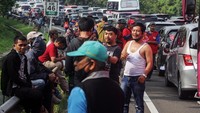 Sebagian pengendara keluar dari mobilnya saat menunggu antrean panjang kendaraan menuju kawasan wisata Puncak, Gadog, Kabupaten Bogor, Jawa Barat.