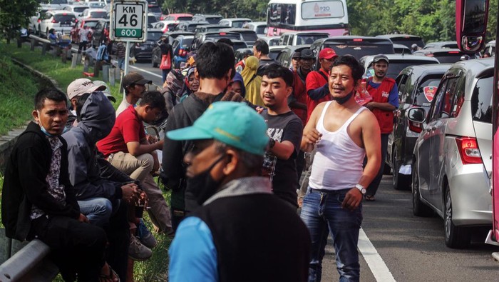 Wisatawan keluar dari kendaraan saat menunggu antrean panjang kendaraan menuju kawasan wisata Puncak, Gadog, Kabupaten Bogor, Jawa Barat, Sabtu  (30/7/2022).  Sat Lantas Polres Bogor memberlakukan sistem buka tutup jalur untuk mengurai kepadatan kendaraan di jalur Puncak Bogor imbas tingginya antusiasme warga untuk berlibur di kawasan tersebut pada libur Tahun Baru Islam 1 Muharam 1444 Hijriyah. ANTARA FOTO/Yulius Satria Wijaya/rwa.