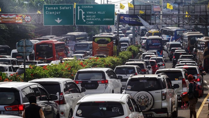 Wisatawan keluar dari kendaraan saat menunggu antrean panjang kendaraan menuju kawasan wisata Puncak, Gadog, Kabupaten Bogor, Jawa Barat, Sabtu  (30/7/2022).  Sat Lantas Polres Bogor memberlakukan sistem buka tutup jalur untuk mengurai kepadatan kendaraan di jalur Puncak Bogor imbas tingginya antusiasme warga untuk berlibur di kawasan tersebut pada libur Tahun Baru Islam 1 Muharam 1444 Hijriyah. ANTARA FOTO/Yulius Satria Wijaya/rwa.