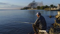 Seorang warga sedang mancing di sungai kawasan Vyshhorod, Kyiv, Ukraina, pada Kamis (28/7/2022). AP Photo/David Goldman.