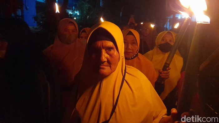 Romlah saat mengikuti pawai obor.