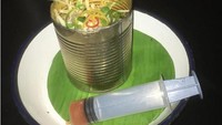 Kaleng makanan tampaknya jadi pilihan populer untuk menyajikan makanan. Kali ini salad pepaya disajikan di di dalam kaleng dan uniknya dressing saladnya menggunakan suntikan jarum yang aneh. Foto: Twitter/DailyMailUK