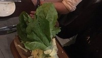 Seorang wanita di Afrika mengabadikan momen saat ia makan di restoran mewah. Caesar salad pesanannya disajikan di atas kayu dengan sayuran masih terikat rapih dan irisan keju yang berantakan. Duh! Foto: Twitter/DailyMailUK