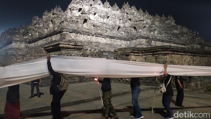 Peringatan malam satu suro dengan membentangkan kain putih kelilingi Candi Borobudur, Minggu (31/7/2022).