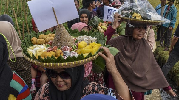 Warga mengarak makanan beubeutian atau makanan tradisional pada Festival Kolecer dan Beubeutian di Kampung Cisayong, Kabupaten Tasikmalaya, Jawa Barat, Minggu (31/7/2022).