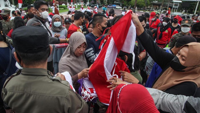 Petugas membagikan bendera merah putih kepada warga dalam aksi Gerakan Pembagian Satu Juta Bendera Merah Putih di Bundaran Besar, Palangka Raya, Kalimantan Tengah, Minggu (31/7/2022). Aksi yang diselenggarakan oleh Pemprov Kalteng tersebut dilakukan secara serentak di provinsi itu bertujuan untuk menumbuhkan rasa jiwa nasionalisme kepada masyarakat sekaligus menyemarakkan HUT ke-77 Kemerdekaan Republik Indonesia. ANTARA FOTO/Makna Zaezar/foc.